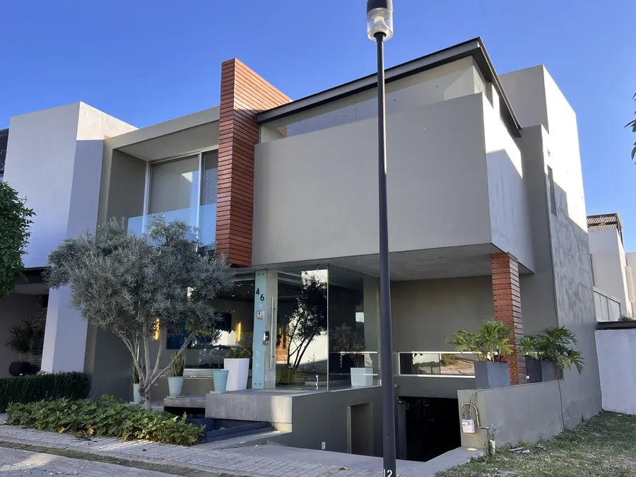 Fachada moderna con acento de tabique y ventanería — casa residencial construida por Prisma Habita en Puebla