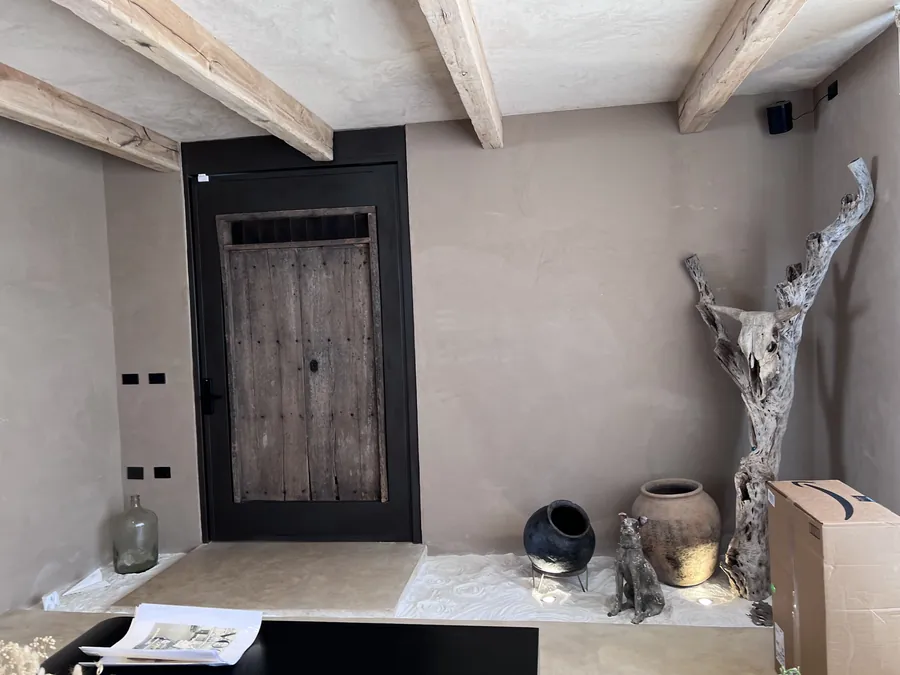 Recibidor con puerta rústica de madera y escultura de raíz — casa residencial construida por Prisma Habita en Puebla