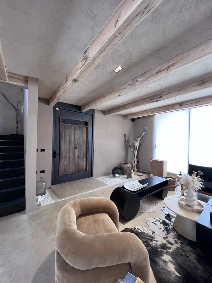 Sala cálida con tapete de piel y vigas — casa residencial construida por Prisma Habita en Puebla