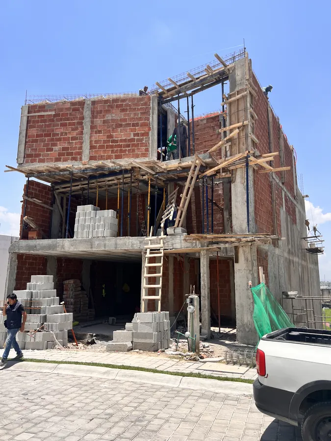 Casa en construcción con tabique, andamios y cuadrilla — proceso de construcción de casa residencial en Puebla