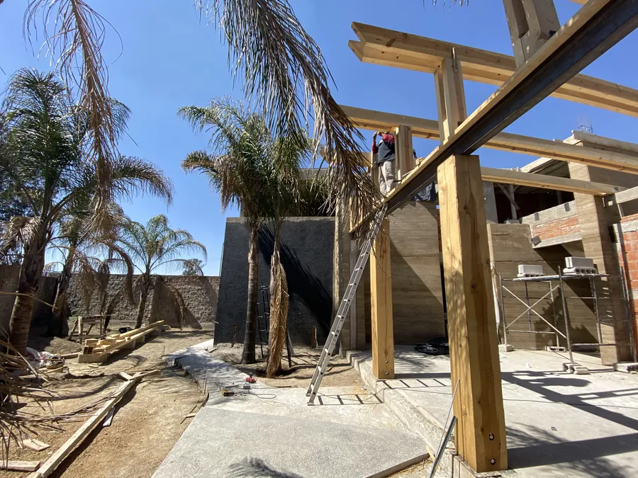 Estructura de madera y palmeras en obra de jardín — proceso de construcción de casa residencial en Puebla