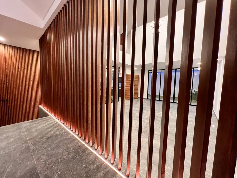 Muro de celosía de madera retroiluminado — residencia contemporánea de doble altura en Puebla