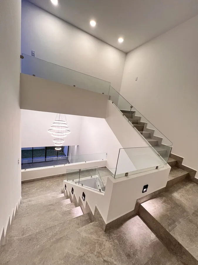 Escalera a doble altura con candil esférico — residencia contemporánea de doble altura en Puebla