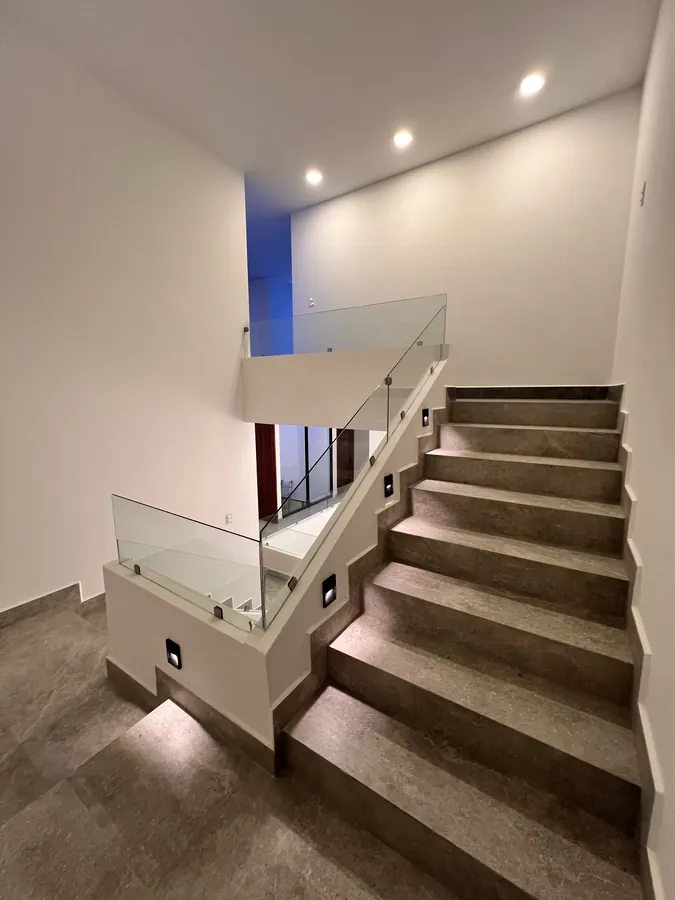 Escalera escultural de concreto a doble altura — residencia contemporánea de doble altura en Puebla