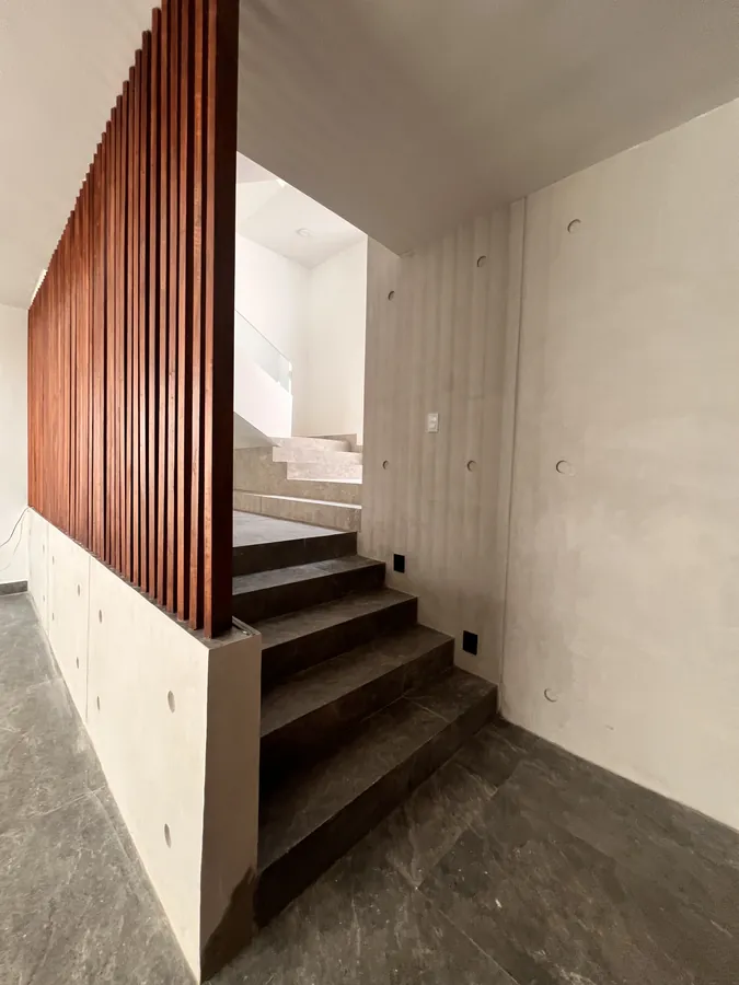 Escalera volada con muro de madera — residencia contemporánea de doble altura en Puebla