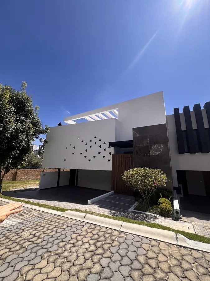 Fachada contemporánea en blanco y negro al anochecer — residencia contemporánea de doble altura en Puebla