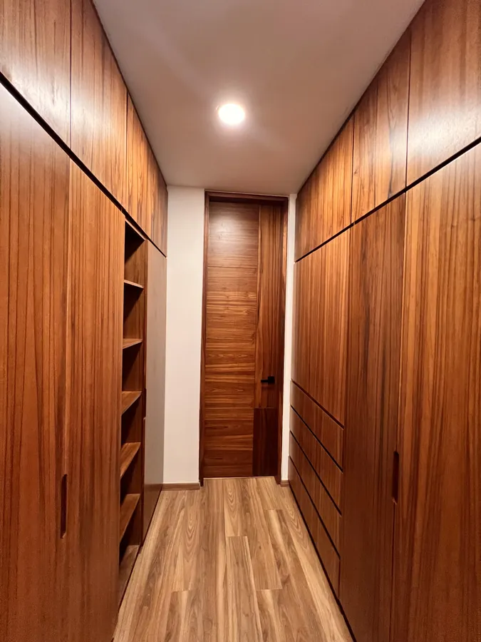 Vestidor de madera tipo pasillo — residencia contemporánea de doble altura en Puebla