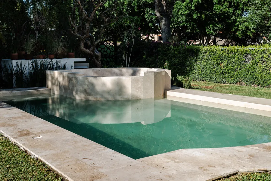 Alberca de agua turquesa con acabado de piedra — casa residencial de autor en Atlixco, Puebla