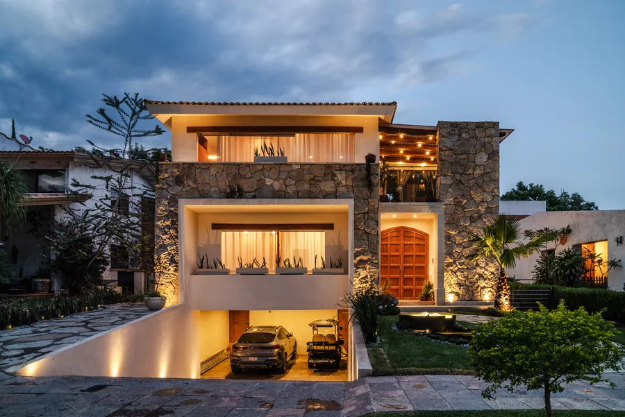 Fachada nocturna con acceso y jardines iluminados — casa residencial de autor en Atlixco, Puebla