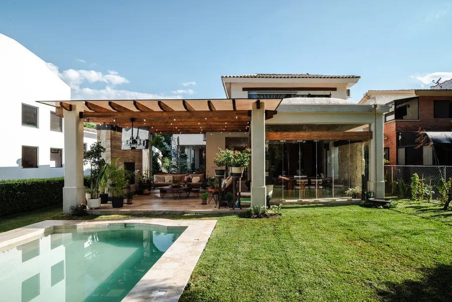 Jardín con alberca y pérgola de madera vista de día — casa residencial de autor en Atlixco, Puebla