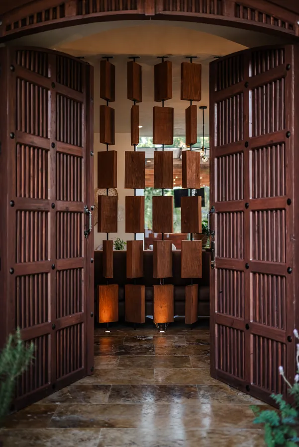 Puertas de celosía de madera con luz cálida — casa residencial de autor en Atlixco, Puebla