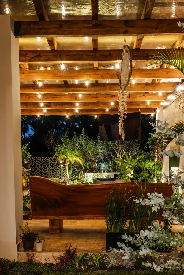 Terraza bajo pérgola con series de luces al anochecer — casa residencial de autor en Atlixco, Puebla