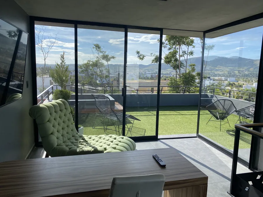 Sala con ventanal panorámico en esquina y vista al valle — penthouse en Lomas de Angelópolis, Puebla